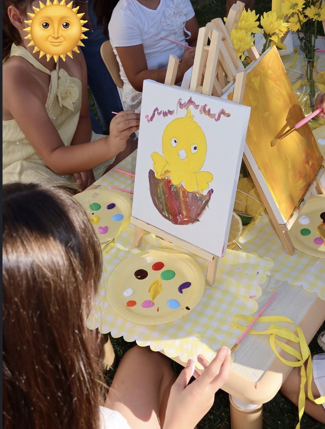 Children creating paintings together during an outdoor art activity