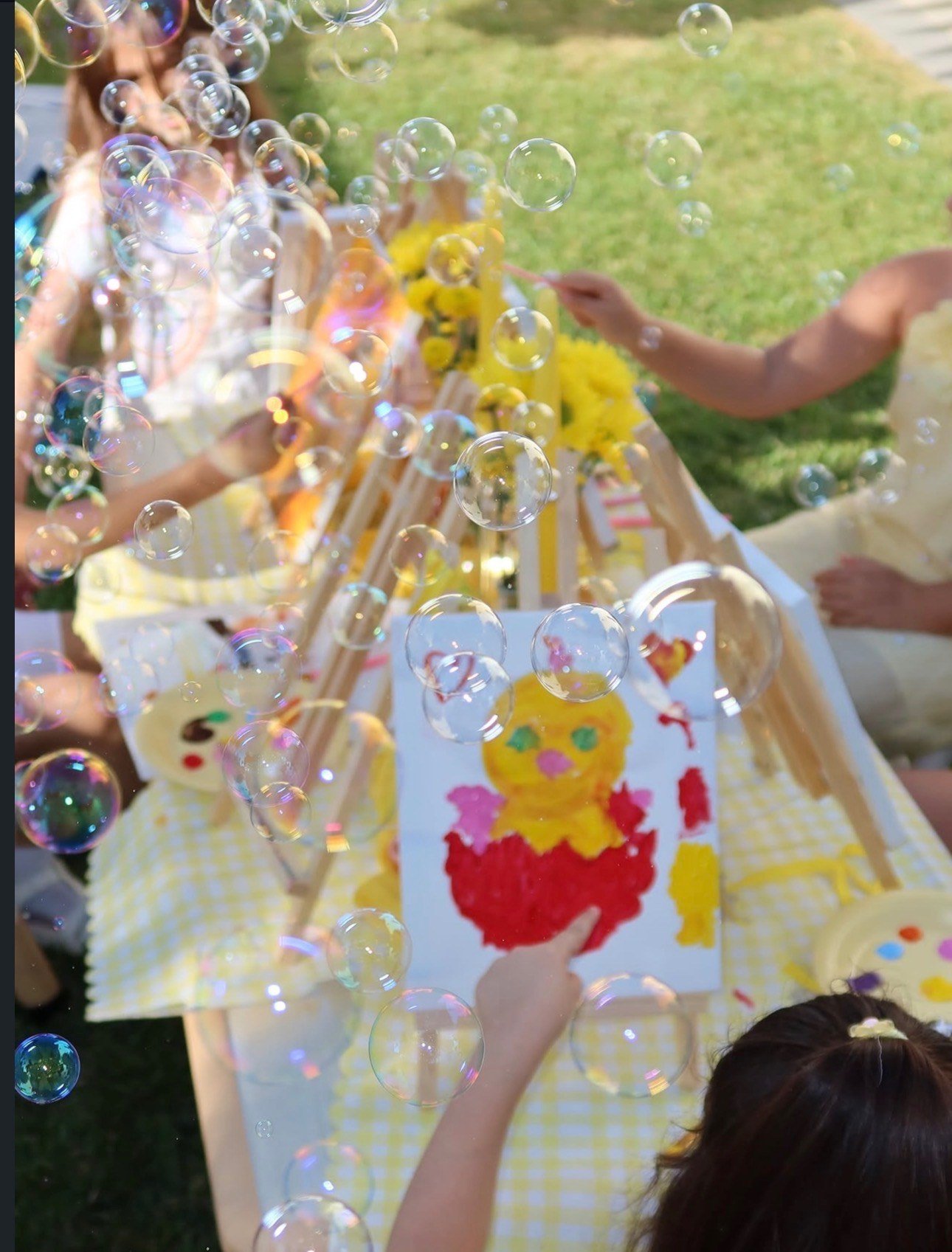 Children enjoying bubbles and art during outdoor play at Top-Top Day Care